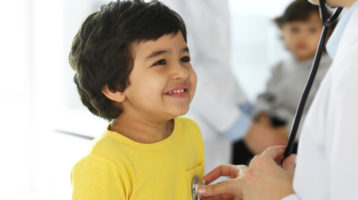 Doctor examining a child patient by stethoscope.